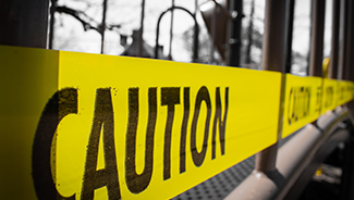 Caution tape over the front window of an office building following a disaster.