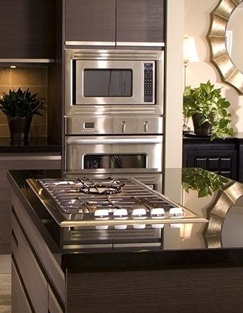 A kitchen island with a gas cooktop and two stacked ovens.