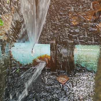 Water spraying from a burst water line pipe.