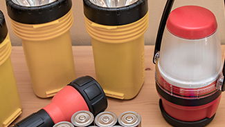 Shelf displaying multiple flashlights, extra batteries, and a lantern.